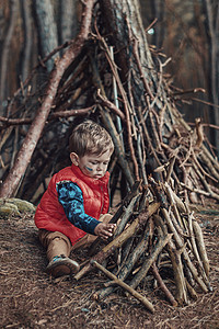 可爱的小男孩建造了间木制的小屋图片
