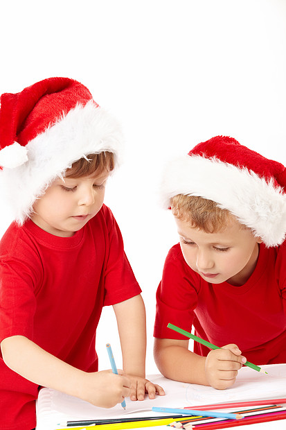 两个戴着圣诞老人帽子的小男孩床单上画画图片