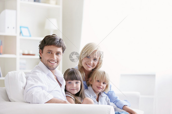 个年轻的家庭,有两个孩子家里的白色沙发上图片