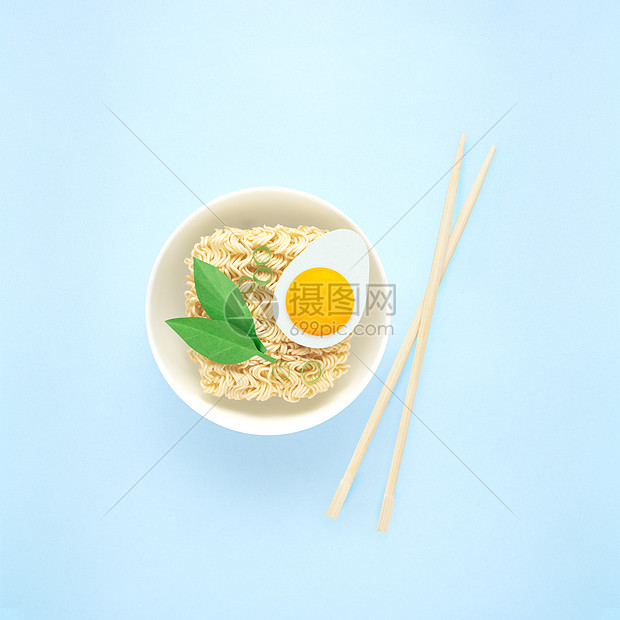 创意食物饮食健康饮食照片,美味拉面面条意大利面与鸡蛋,绿色筷子碗蓝色背景图片