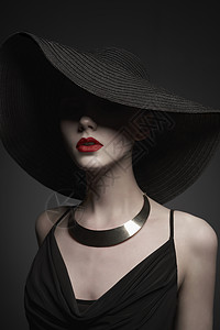 时尚肖像年轻感女士与美丽的黑色帽子晚礼服时尚优雅的女人与现代珠宝灰色背景上漂亮模特的工作室照片背景图片