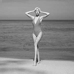 热带海滩上美丽感的女士时尚的女人,苗条完美的身材走海边模特姿势海洋附近的复古泳装放松年轻日光浴美女的肖像图片