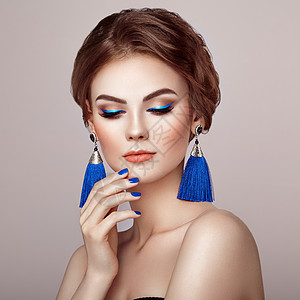 美丽的女人,大耳环,流苏,珠宝,蓝色完美的妆容优雅的发型蓝色化妆箭头蓝色指甲修剪图片