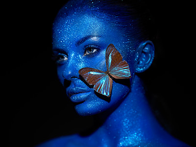 时尚模特女人穿着蓝色明亮的火花霓虹灯工作室摆姿势蓝的美丽感女人的肖像艺术彩色闪光发光化妆图片