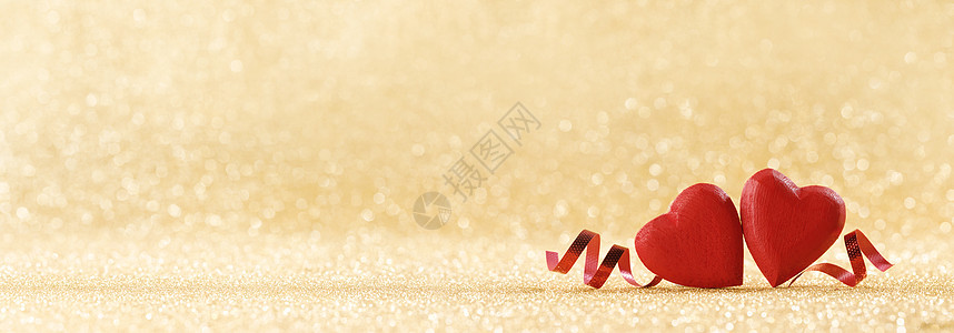 两颗红色手工木心丝带金色明亮的闪光灯光博克背景闪闪发光的背景上的红心图片