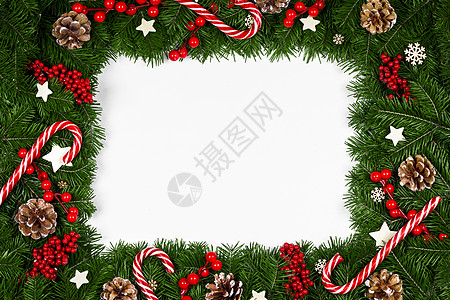 圣诞节边框装饰圣诞边框的树枝围绕白色背景与隔离,红色装饰,浆果,星星,锥,糖果罐头圣诞树树枝的圣诞框架背景