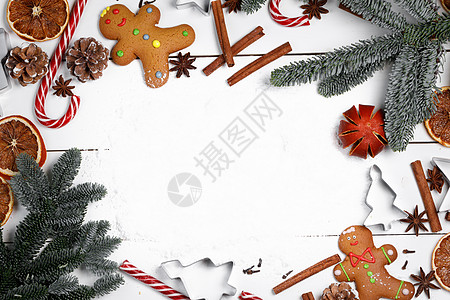 圣诞藤条圣诞装饰食品框架姜饼饼干,香料,糖果罐头冷杉树枝雪白的背景上,有圣诞装饰框架背景