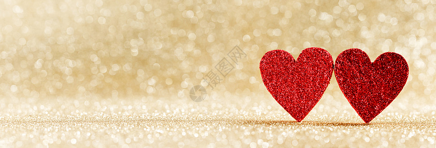 两颗小小的手工红色闪光的心明亮的金色灯光博克背景情人节卡片上两颗心博克的背景下图片