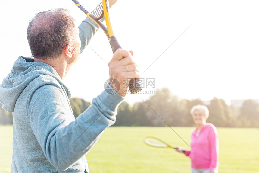 阳光明媚的日子里,老人公园里打羽毛球图片