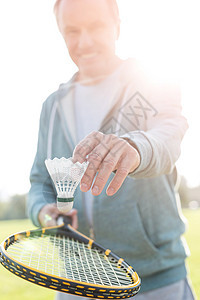 活跃的老人公园用网球拍打羽毛球图片