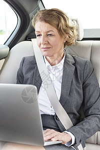 自信成熟的女商人车里用笔记本电脑图片