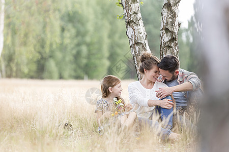 女儿坐农田里看着慈爱的父母图片