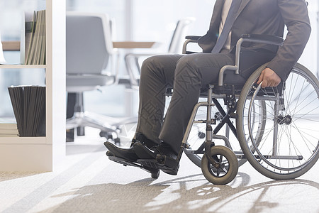 现代办公室轮椅上残疾商人的低角度视角图片
