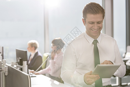 微笑的商人与数字平板电脑现代办公室图片