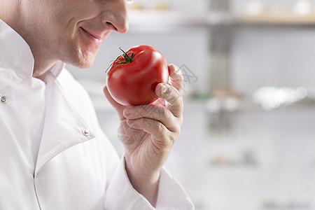 厨师餐厅厨房里闻着新鲜的西红柿图片
