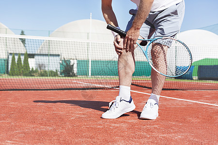 男人腿男子手持网球拍膝盖疼痛背景