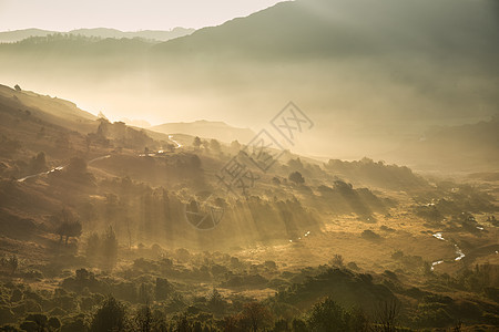 阳光透过薄雾流入朗代尔山谷的日出湖区秋景图,背景图片