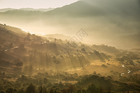 阳光透过薄雾流入朗代尔山谷的日出湖区秋景图,图片