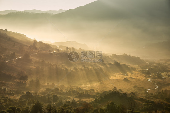 阳光透过薄雾流入朗代尔山谷的日出湖区秋景图,图片