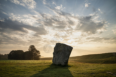美丽的夏季日出景观,新石器时代站立的石头英国农村与华丽的光与背景雾图片