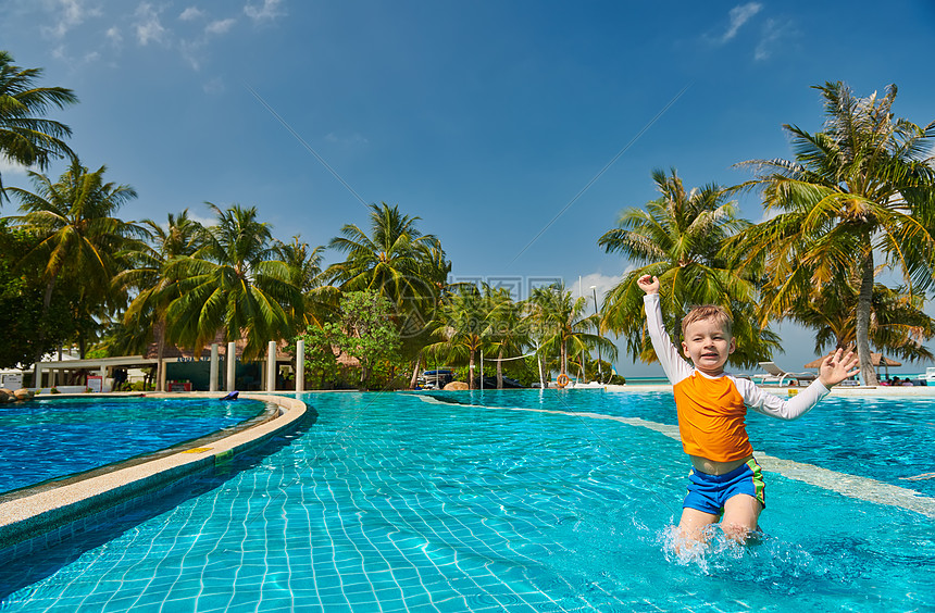 三岁的蹒跚学步的男孩度假游泳池马尔代夫的暑假家庭假期图片