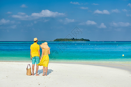 穿着黄色衣服的夫妇热带海滩上马尔代夫的暑假图片
