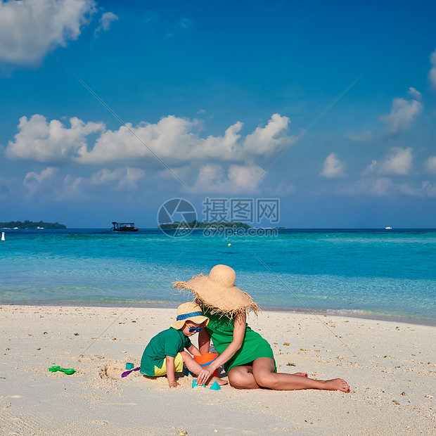 海滩上的家人,穿着绿色连衣裙的女人三岁的男孩马尔代夫的暑假图片