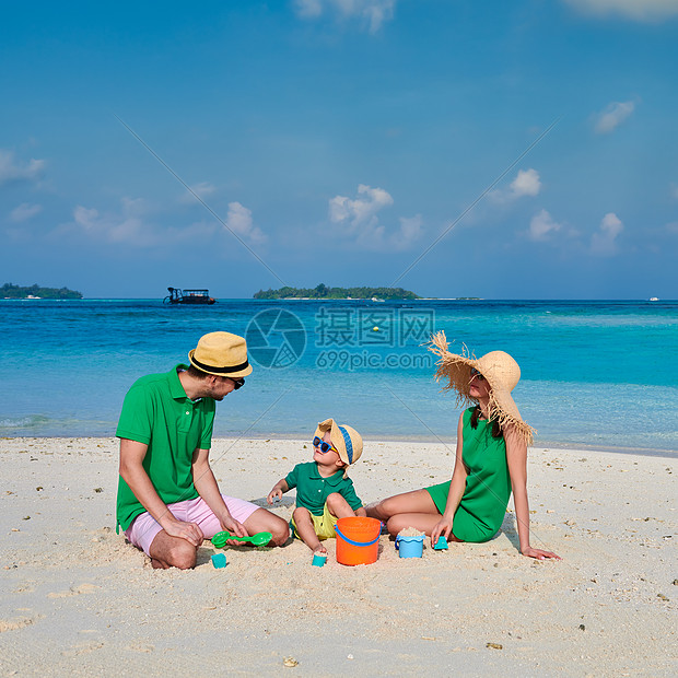 海滩上的家人,穿着绿色衣服的轻夫妇三岁的男孩马尔代夫的暑假图片