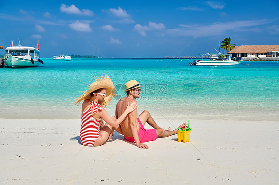 海滩上的轻夫妇女男背部涂防晒霜马尔代夫的暑假图片