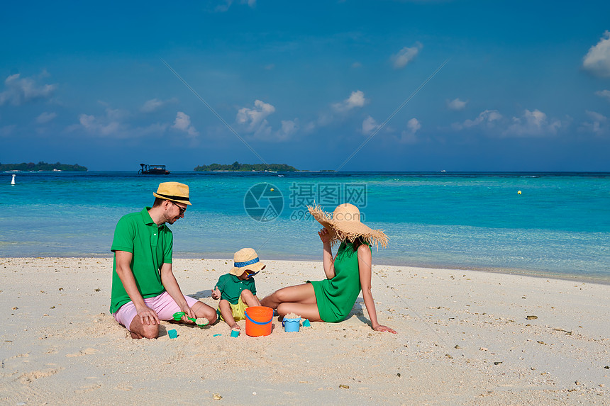 海滩上的家人,穿着绿色衣服的轻夫妇三岁的男孩马尔代夫的暑假图片