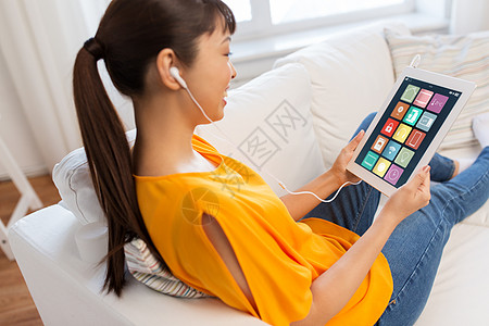 耳机icon自动化,物联网人的快乐的轻亚洲妇女坐沙发上的耳机与智能家居图标平板电脑屏幕上平板电脑屏幕上智能家居图标的亚背景