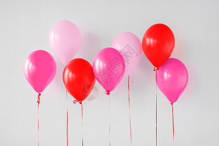 情人节生日派装饰粉红色红色气球白色墙壁上生日派的粉红色红色气球图片