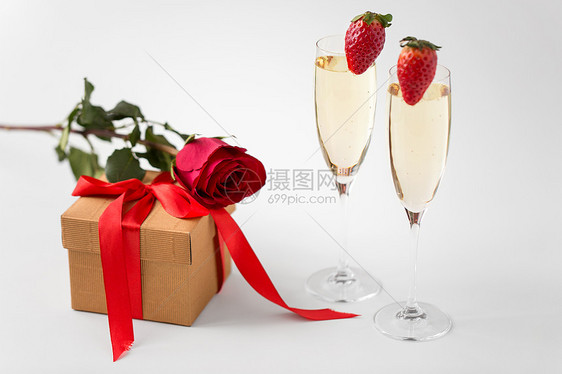 情人节假日两个香槟杯草莓礼品盒与红色玫瑰白色背景两个香槟杯带红玫瑰的礼物图片