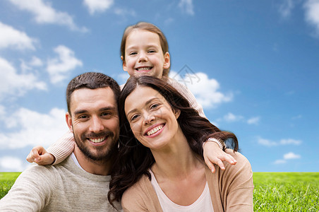 家庭人的快乐的母亲,父亲小女儿蓝天草地背景蓝天草地背景下的幸福家庭图片
