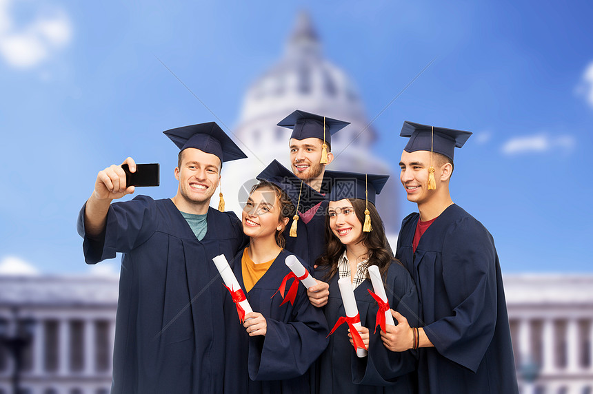教育,毕业人的群快乐的研究生迫击炮板学士学位礼服与文凭采取自拍智能手机华盛顿白宫背景毕业证书的毕业生用手机自图片
