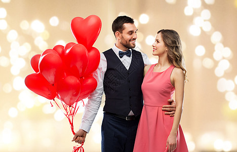 情人节,爱人的幸福的夫妇与红色心形气球节日的灯光背景幸福的红色心形气球图片
