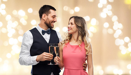 庆祝人们的幸福的夫妇与香槟杯米色背景节日灯上品尝幸福的夫妇戴着香槟酒杯祝酒图片