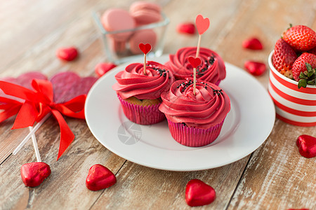 情人节糖果糖霜纸杯蛋糕,红色心形巧克力糖果,棒棒糖,马卡龙草莓情人节的红色糖果图片