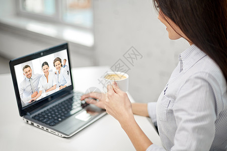 商业,技术通信女商人与笔记本电脑,与合作伙伴举行视频会议,并办公室喝咖啡女人喝咖啡开视频会议图片