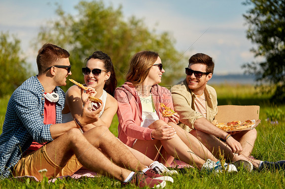 友谊休闲食物群微笑的朋友夏季公园野餐时吃比萨饼朋友们夏天公园野餐时吃比萨饼图片