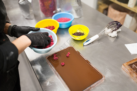 生产,烹饪人的糖果制作巧克力与覆盆子糖果店厨房糖果师糖果店巧克力甜点图片