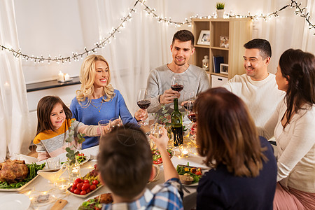 庆祝,节日人们的快乐的家庭吃晚餐聚会,喝红酒家品尝幸福的家庭家里举行晚宴背景图片