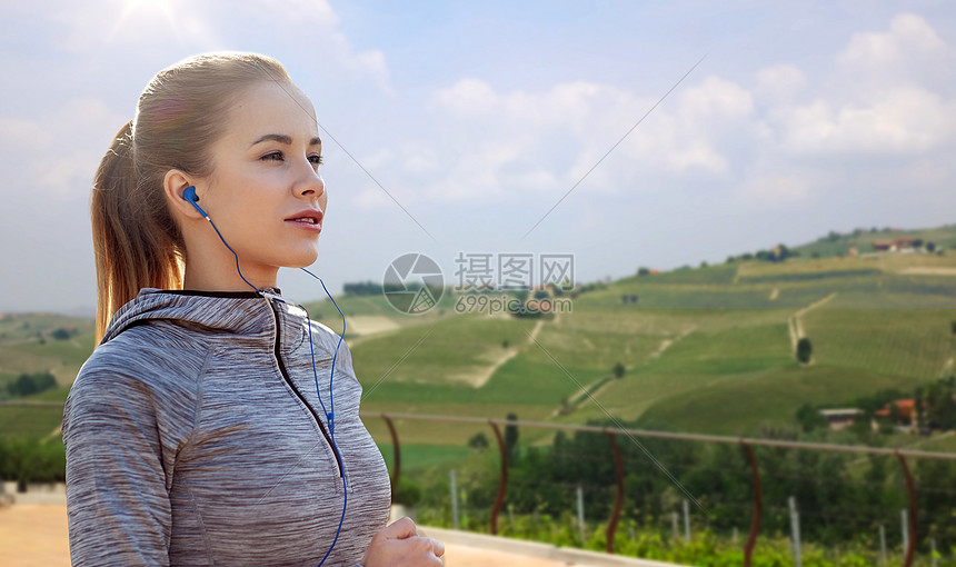 健身,运动,人,技术生活方式的快乐的女人跑步听音乐耳机乡村景观背景戴耳机的女运动员户外跑步图片