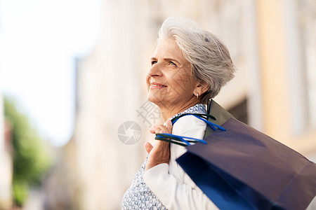 销售,消费主义人的老年女子与购物袋城市城里购物袋的高级女人图片