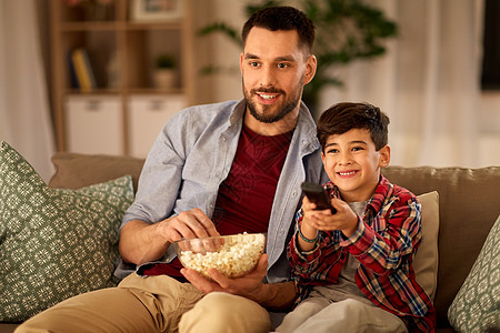 家庭,童,父亲,技术人的快乐的父亲小儿子带着爆米花家看电视父子带着爆米花家看电视图片