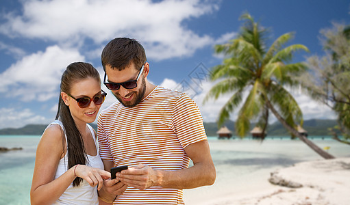 旅行,旅游技术快乐夫妇与智能手机夏季热带海滩背景法属波利尼西亚夏天智能手机的幸福夫妇图片