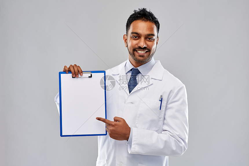 医学,科学职业微笑的印度男医生科学家穿着白色外套,灰色背景的剪贴板上空白纸剪贴板上白纸的医生科学家图片