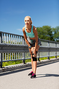 健身,运动,锻炼健康的生活方式轻妇女与膝盖支撑支架腿户外轻的女人,膝盖支撑腿上图片