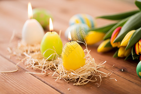 复活节,假日,传统物体三支燃烧的蜡烛,形状为鸡蛋郁金香花木桌上复活节彩蛋郁金香花形状的蜡烛图片