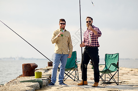 休闲人们的快乐的朋友与鱼竿,鱼啤酒码头海上码头上钓鱼竿啤酒的快乐朋友图片